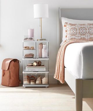 A neutral, clean bedroom with a clear acrylic nightstand