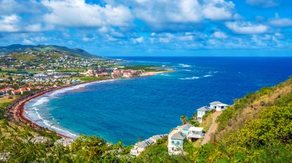 The view of St. Kitts from Timothy Hill on a blue sky day with a few fluffy clouds