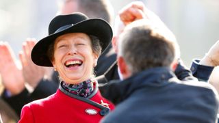 Princess Anne, The Princess Royal watches the racing alongside a cheering racegoer as she attends Day 4 of the Cheltenham Festival at Cheltenham Racecourse on March 14, 2014