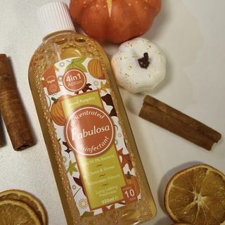Fabulosa Spiced pumpkin scent on white counter next to pumpkns, dried orange slices and cinnamon sticks