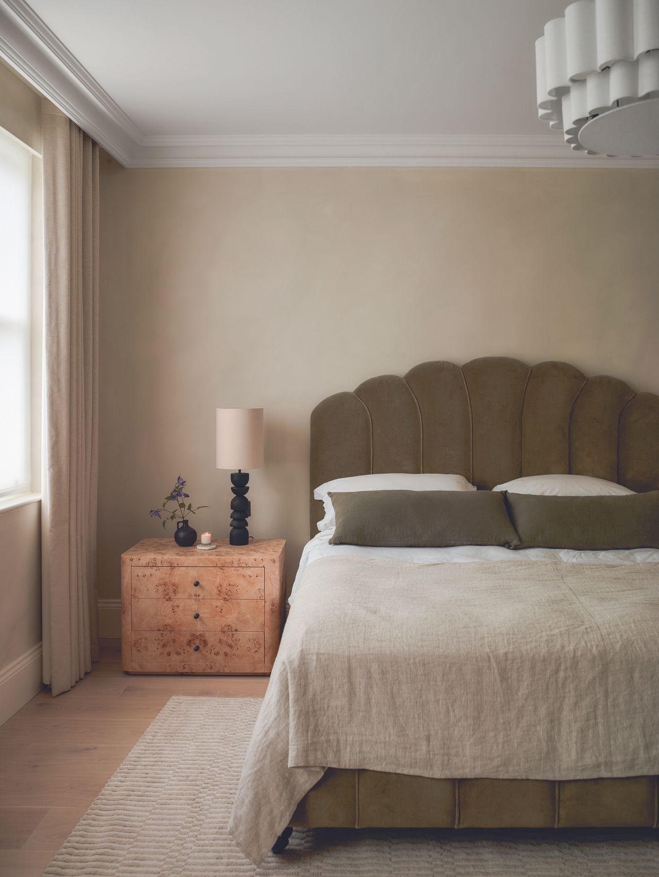 The natural toned bedroom with a wooden bedside table and neutral palette