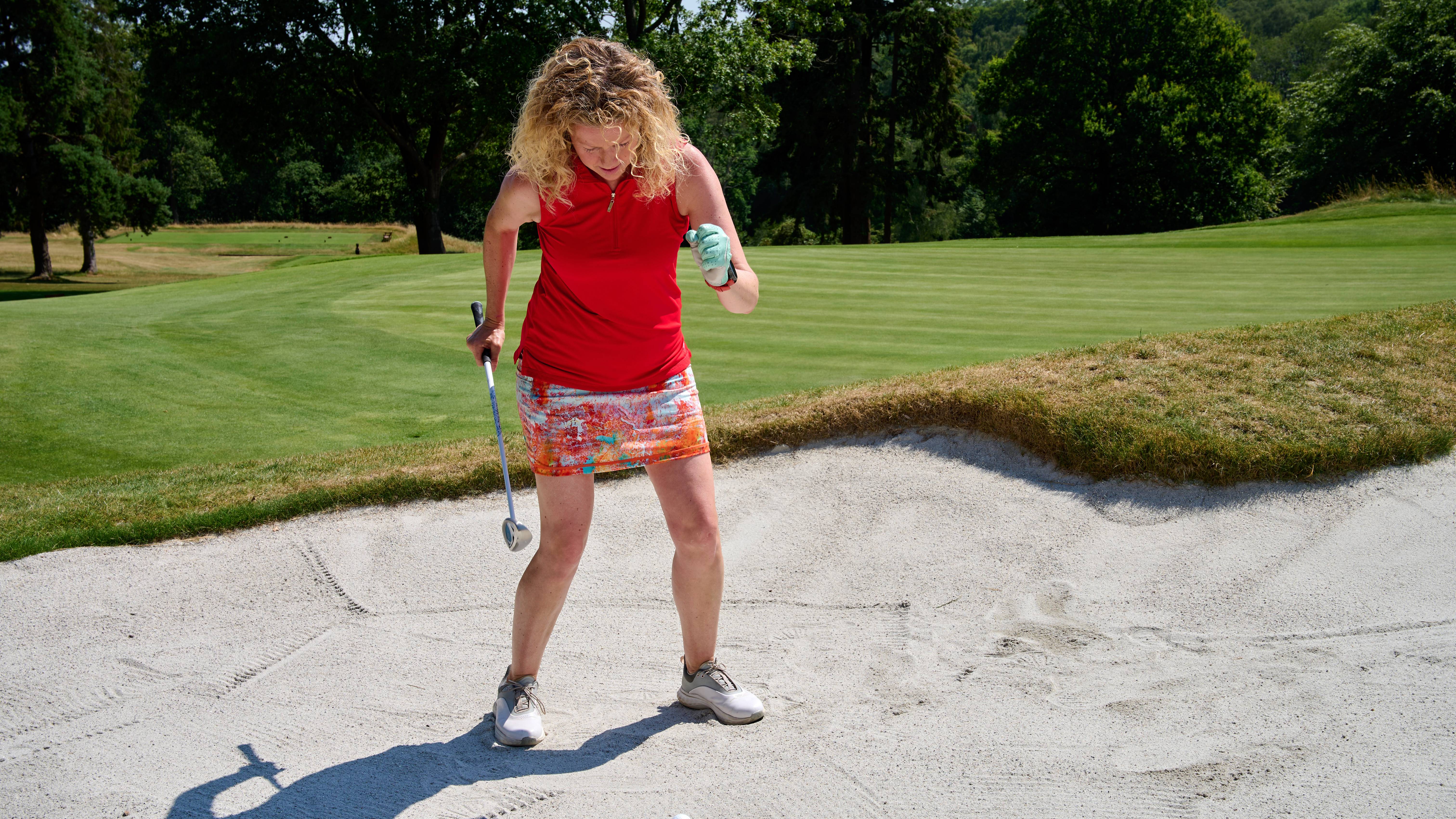 Katie Dawkins wiggling in the sand for a bunker shot