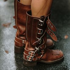 woman wearing brown boots on the street at Paris Fashion Week