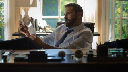 Mark Kimball (Ben Affleck) reads notes in his office and looks desperate in Animals.