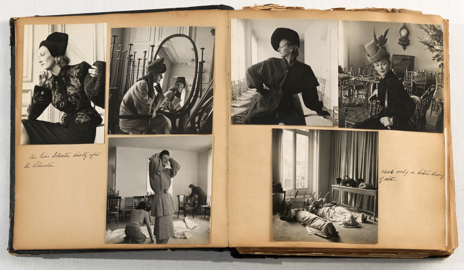 A scrapbook spread of six black-and-white fashion photographs showing elegantly dressed women in post-war Paris interiors, including a self-portrait reflected in a mirror and models in structured coats and wide-brimmed hats.