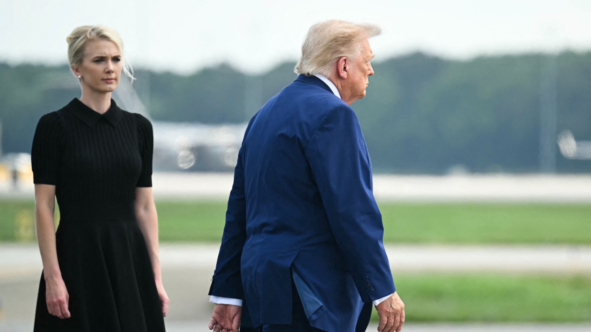 Donald Trump walks past Natalie Harp on a runway