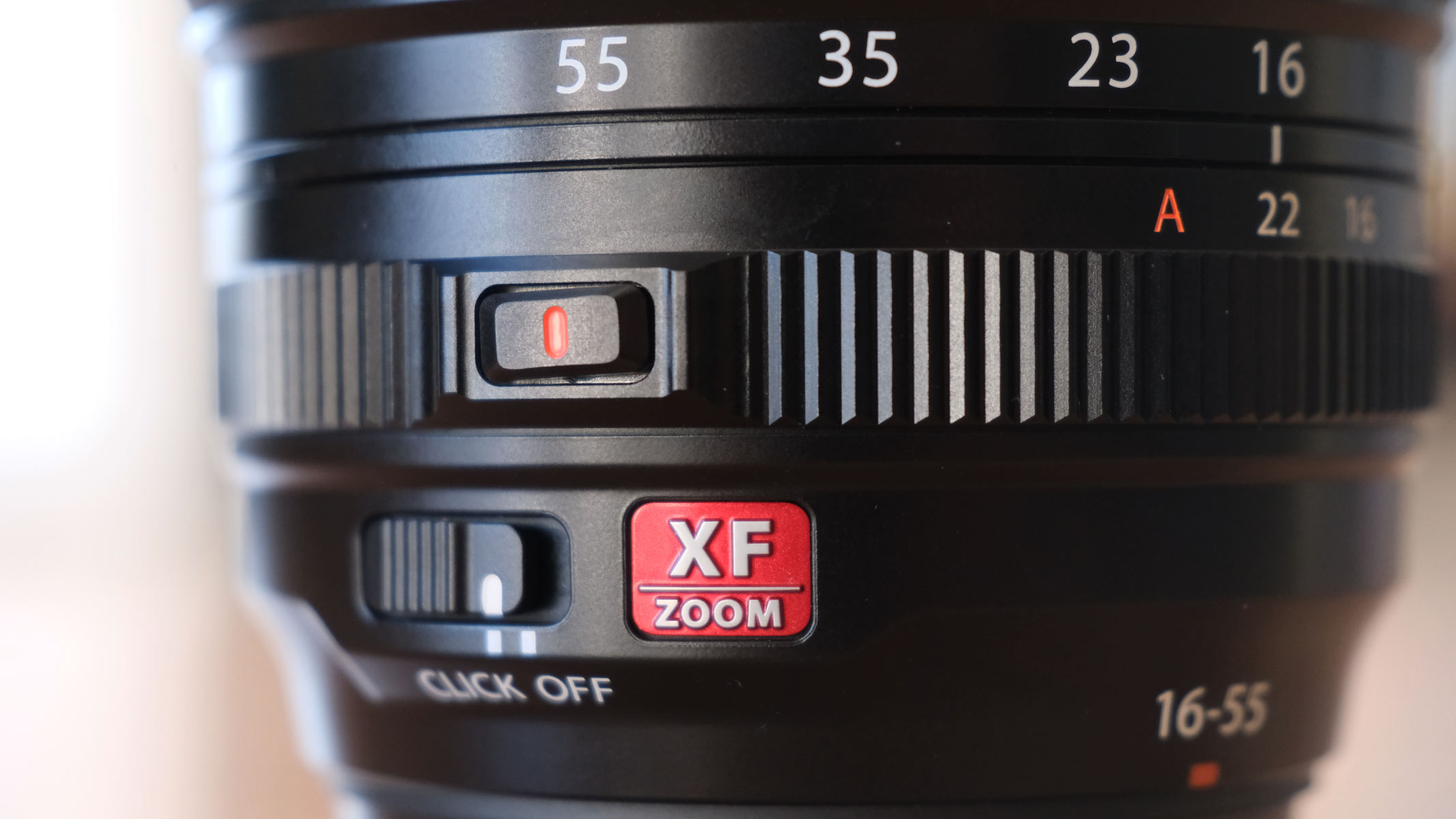 A close-up of the controls on the Fujifilm XF 16-55mm f/2.8 lens LM WR II, including the aperture dial and the noise dampening switch