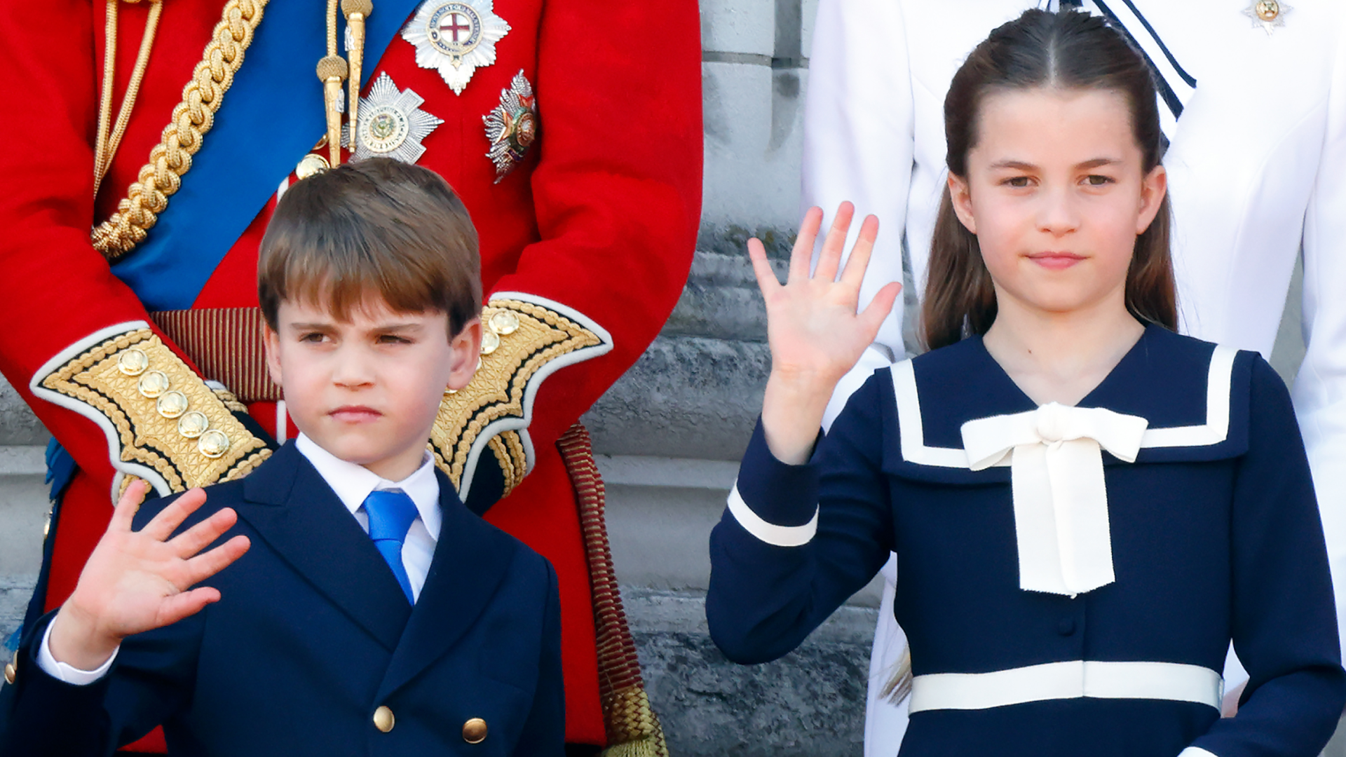 Prince Louis and Princess Charlotte wearing navy outfits and waving on Buckingham Palace&#039;s balcony