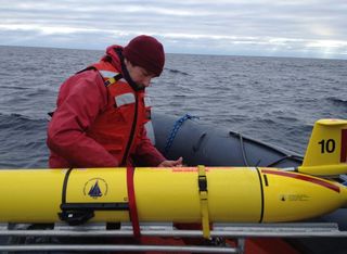 Woods Hole Oceanographic Institution scientist Mark Baumgartner secures a glider (with its wings removed) after it was recovered Dec. 4 from its three-week mission to record and transmit whale song.