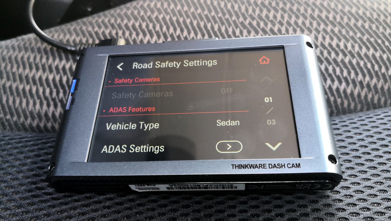 The Thinkware X1000 dash cam sitting on a car seat