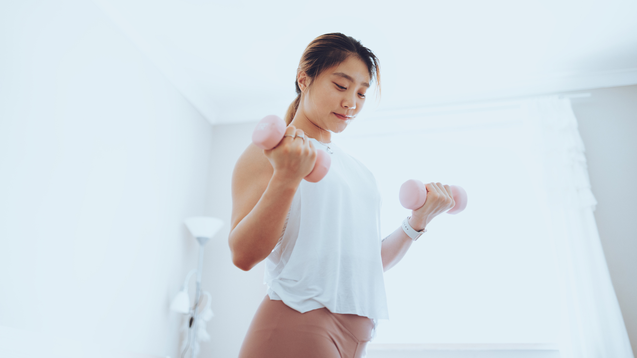 Woman exercising with dumbbells at home
