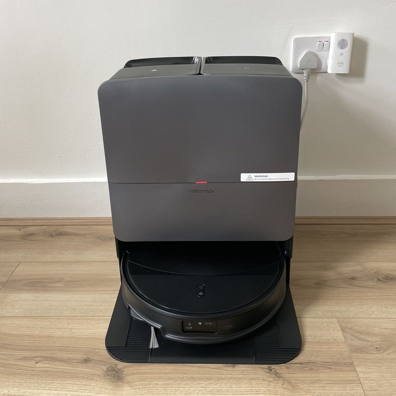 Roborock Saros 20 Robot Vacuum and docking station sitting on wood-effect flooring