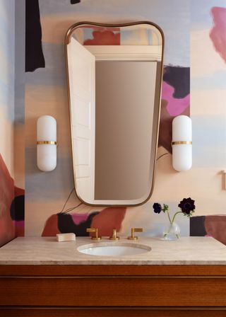 a powder room with a blue beige and pink wallpaper design