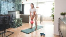 woman holds kettlebell at home
