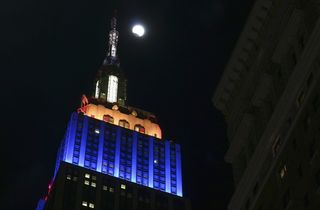 The Super Wolf Blood Moon lunar eclipse begins as the moon rises behind the Empire State Building on Jan. 20, 2019, in New York City. The moon has just entered the outer part, or penumbra, of Earth’s shadow, and has yet to take on the reddish hue of the t