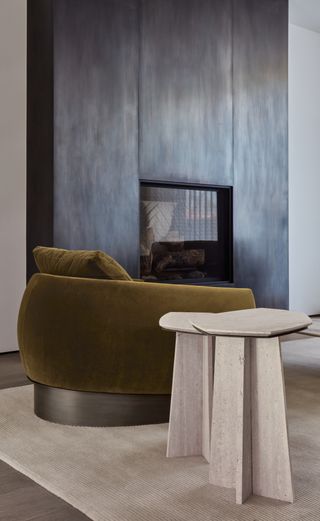 close-up of velvet chair and angular stone side table