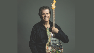 Ex-Yes guitarist Trevor Rabin in a studio-style portrait holding an electric guitar