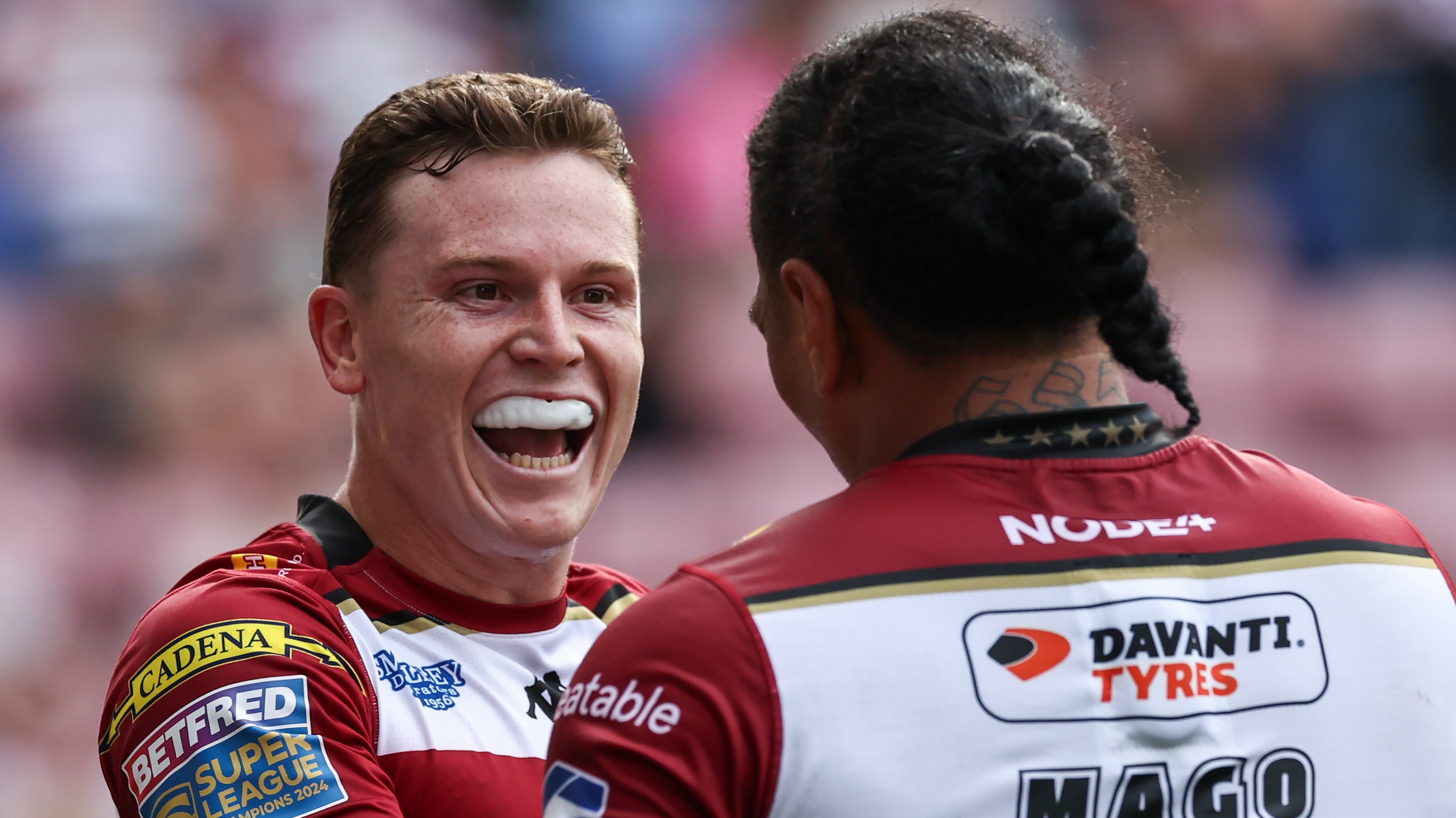 Wigan Warriors' Jai Field celebrates scoring his side's fifth try with Patrick Mago during the Betfred Super League Round 23 match between Wigan Warriors and Wakefield Trinity at Brick Community Stadium on August 24, 2025 in Wigan, England.