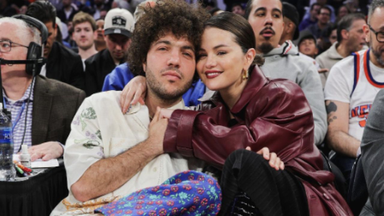 selena gomez and benny blanco sitting at a Knicks game wearing a contrasting outfits