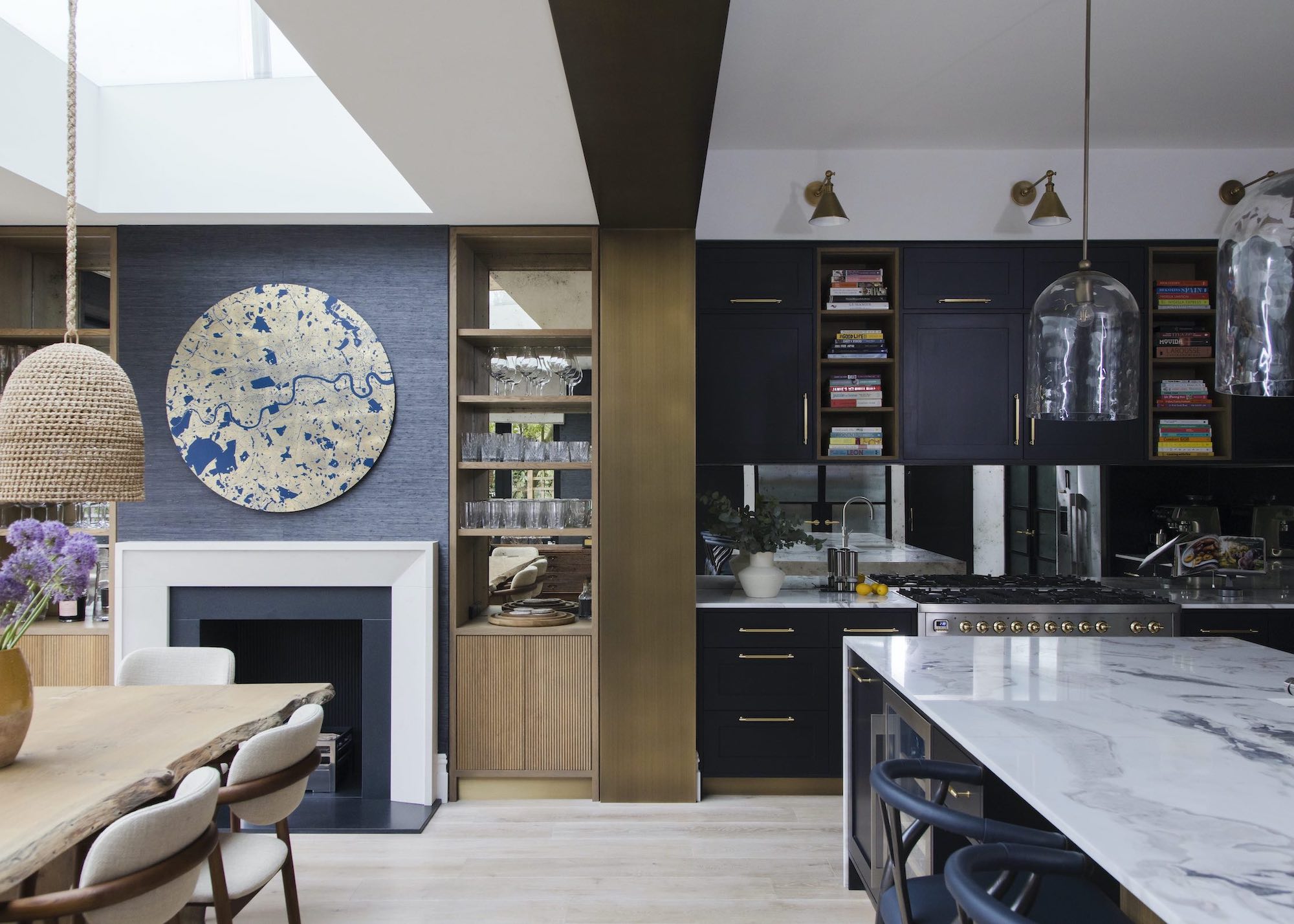 A kitchen extension with a dining table. There is also a bar shelf as well as book shelves scattered near the upper cabinets of this kitchen.