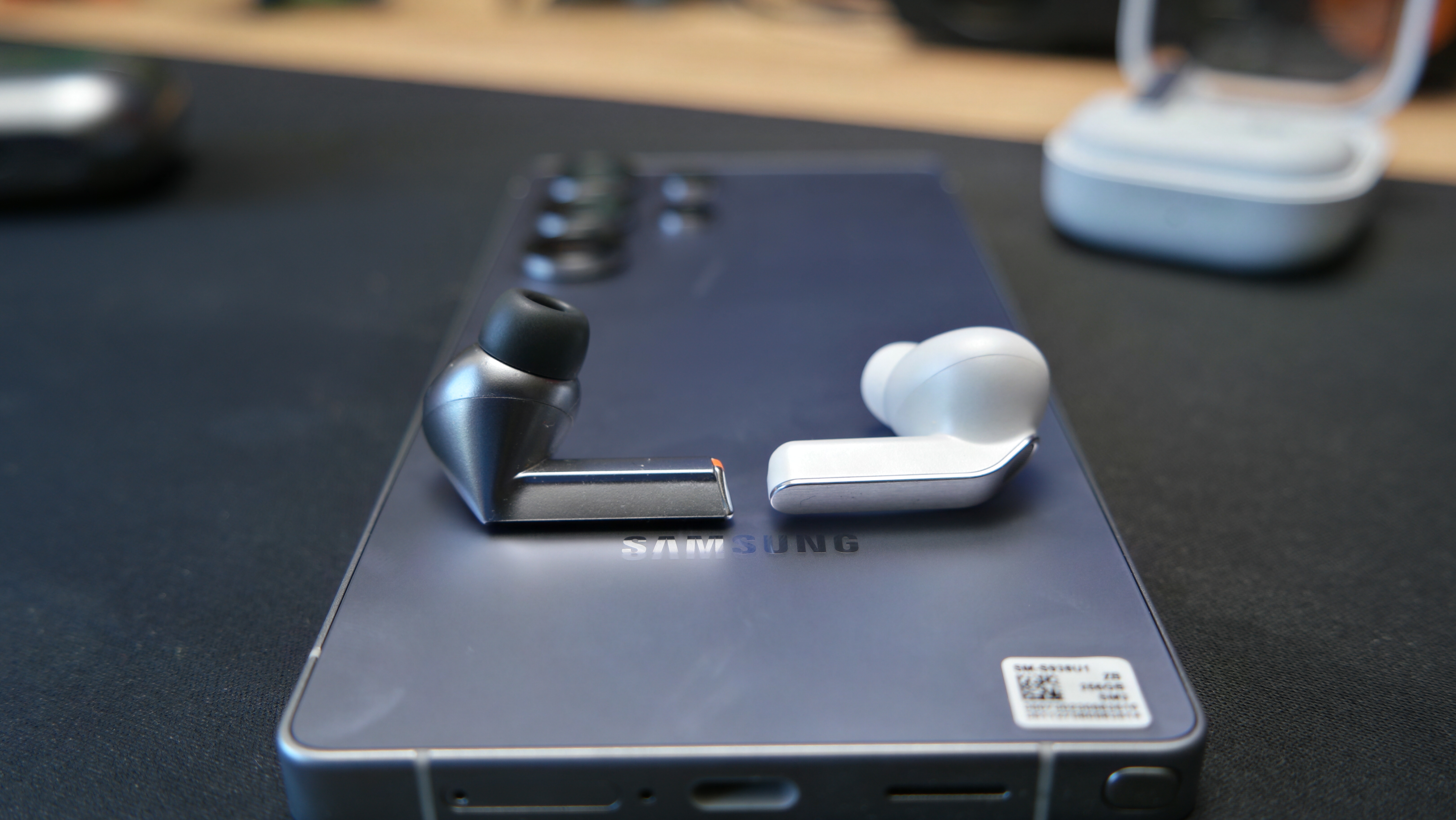 Galaxy Buds 4 Pro on a desk, next to Galaxy Buds3 Pro