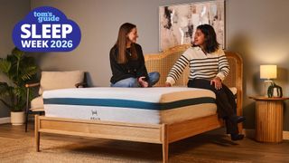 Two Tom's Guide mattress testers sit on the Helix Twilight Mattress in our Sleep Product Testing Lab. A blue Sleep Week 2026 logo is overlaid in the top left hand corner