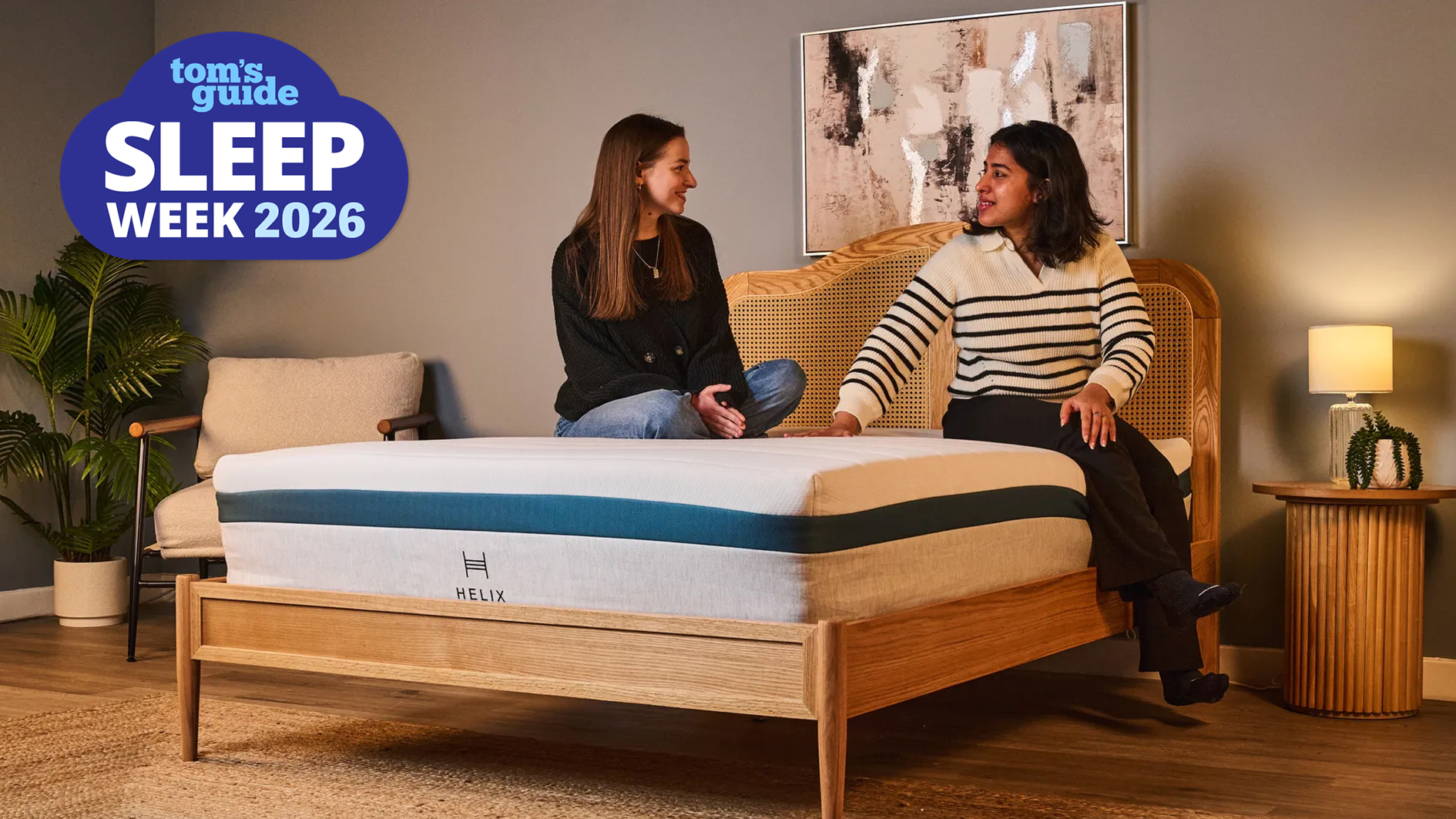 Two Tom's Guide mattress testers sit on the Helix Twilight Mattress in our Sleep Product Testing Lab. A blue Sleep Week 2026 logo is overlaid in the top left hand corner