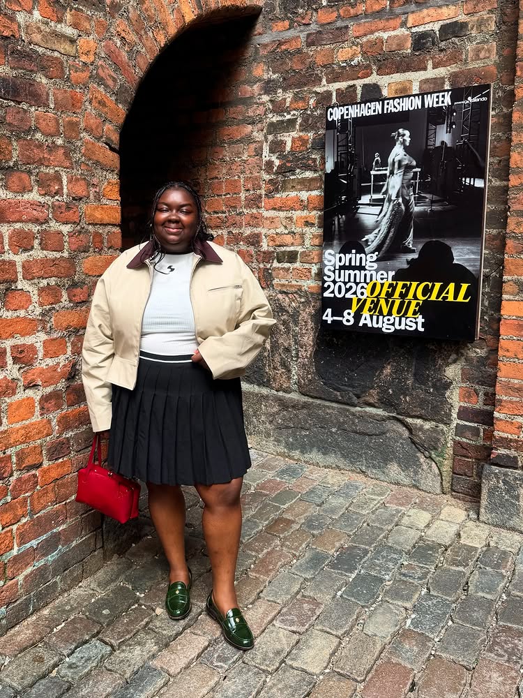 @abimarvel wears a cropped barn jacket with a pleated miniskirt