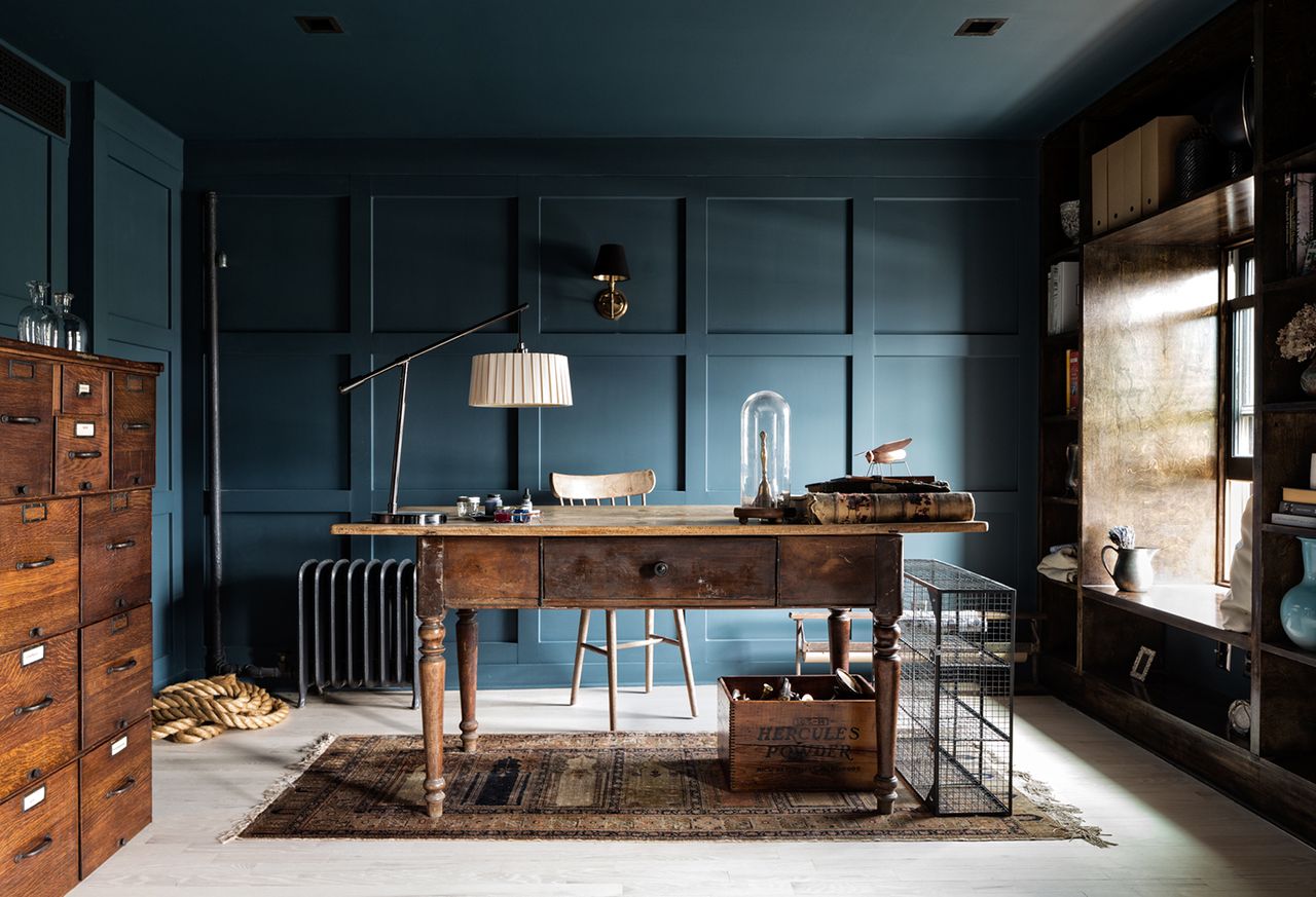 dark blue home office with wainscoting on the walls