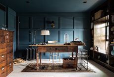 dark blue home office with wainscoting on the walls