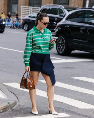 Editor Lauren Eggertsen wearing rugby shirt, miniskirt, and Prada bag during New York Fashion Week.