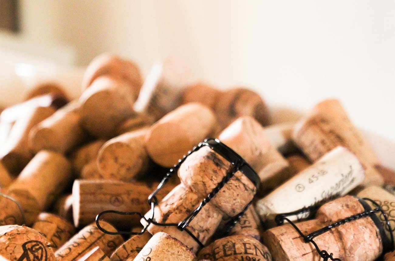 Open NV Champagne; pile of corks