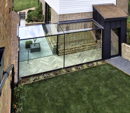 glass additions of a glass box walkway to link two parts of a brick home
