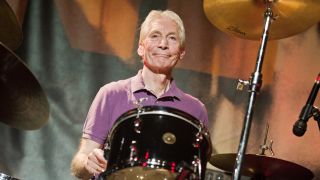 A photograph of Charlie Watts behind the drums