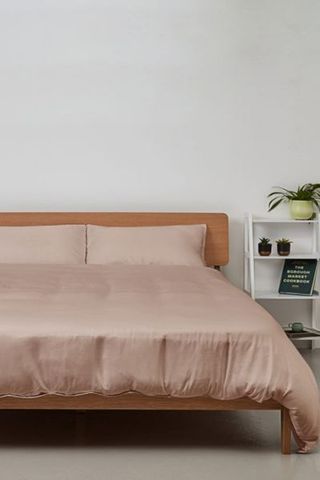 Silky bamboo bedding in beige on bed with wooden bed frame and shelves 