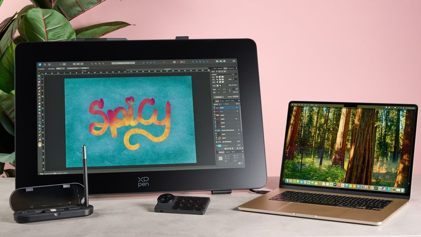 From left to right, there&#039;s a MacBook Air and XPPen drawing display with accessories. There&#039;s some brightly coloured artwork on the display that reads &quot;Spicy&quot;.