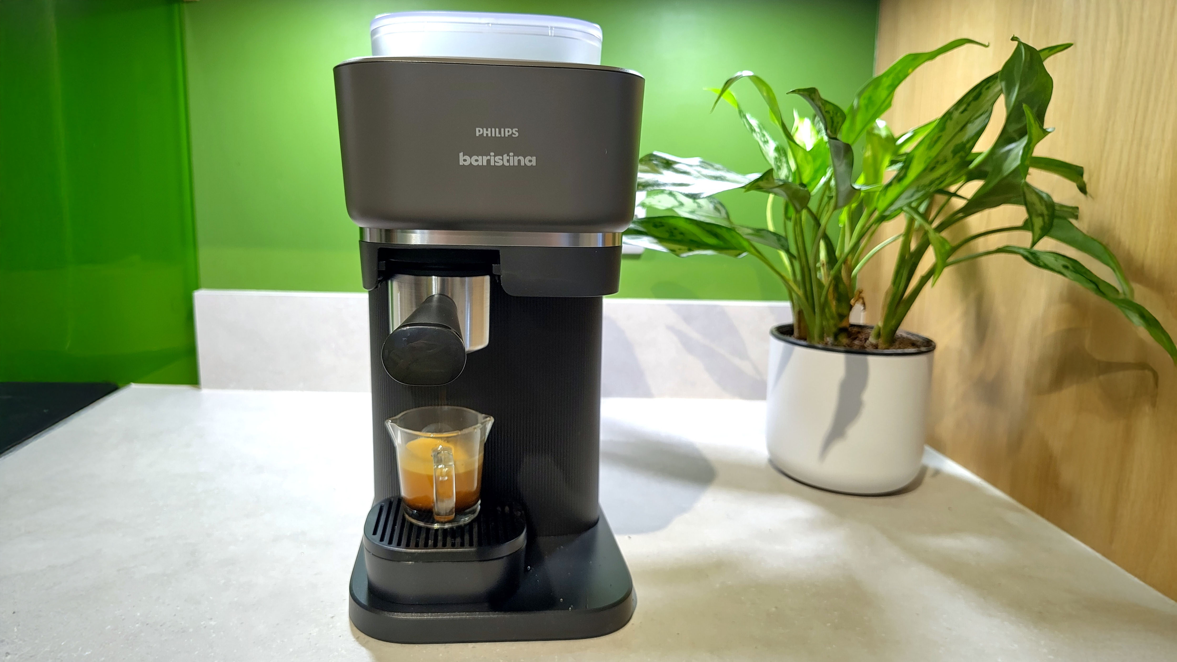 Philips Baristina espresso machine with plant on kitchen counter