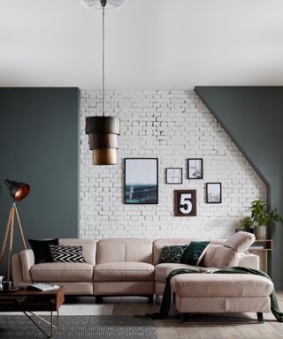 A living room corner idea with white exposed brick wall, gallery wall and pink sofa