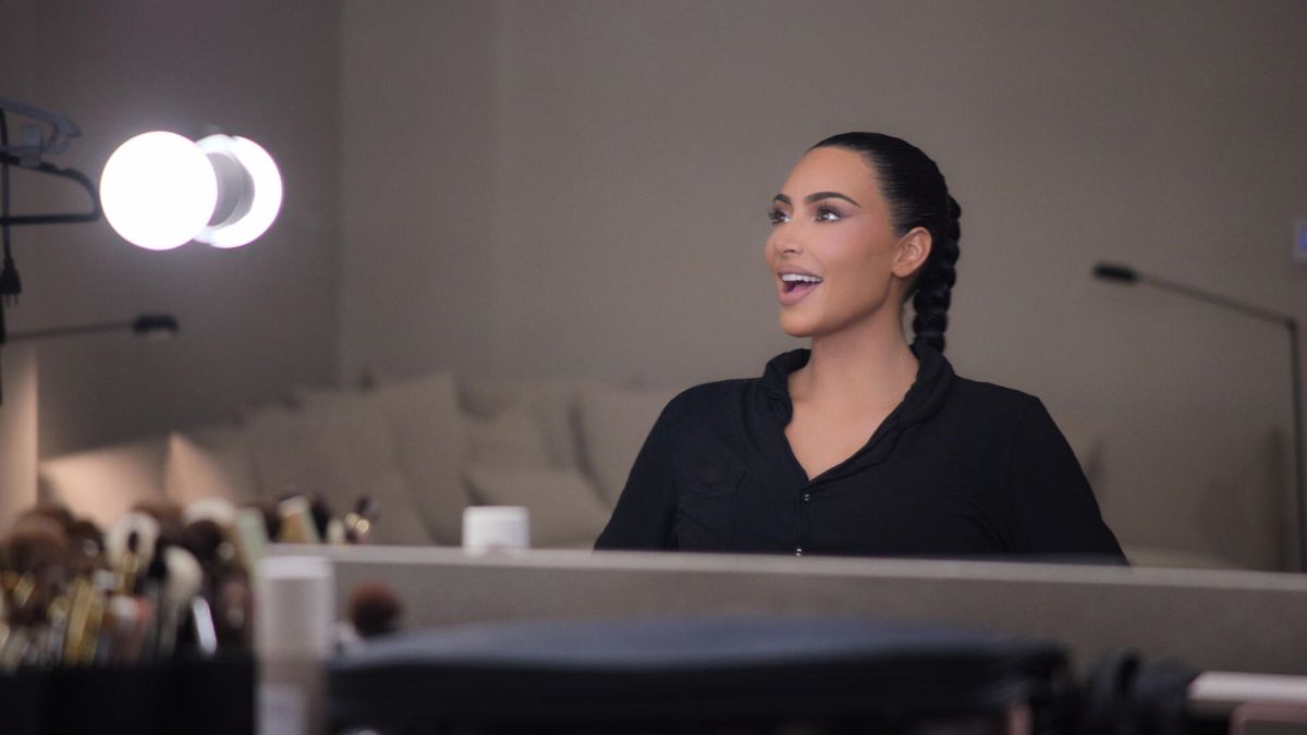 The Kardashians episode 1 - Kim Kardashian smiles at something off-camera. 