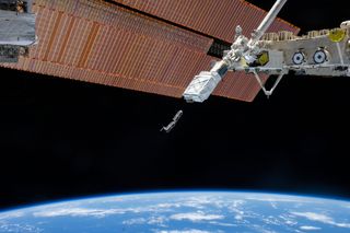 Two of Planet's Dove Earth-observing satellites as seen deploying from the International Space Station.
