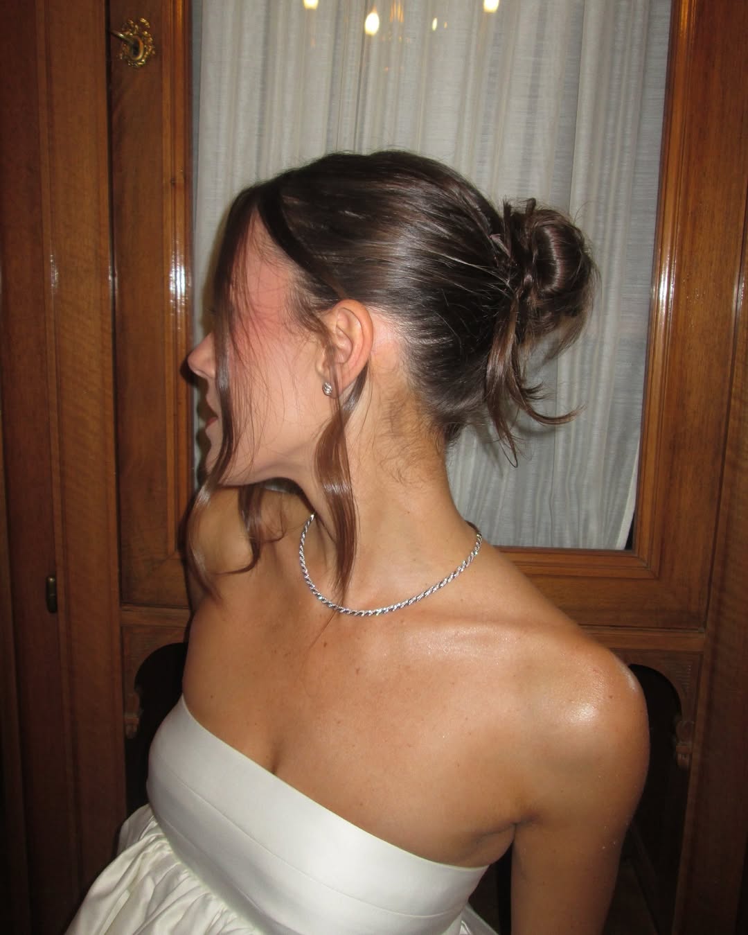 Emma Leger poses in a white peplum top and David Yurman jewelry with a messy bun