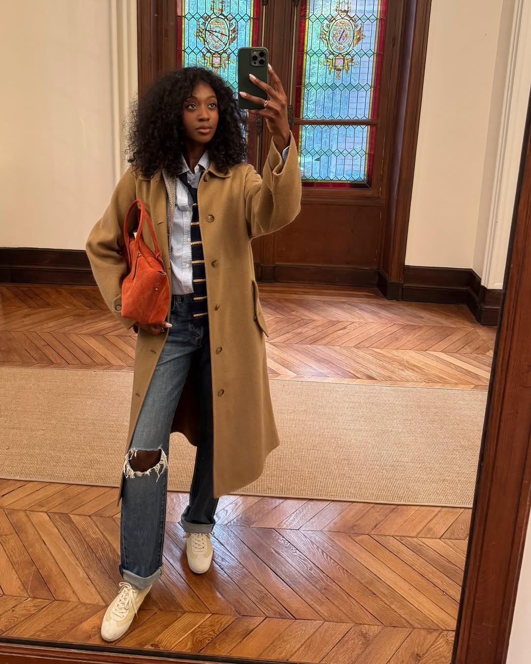 Influencer Emmanuelle Koffi wearing straight jeans and white trainers.