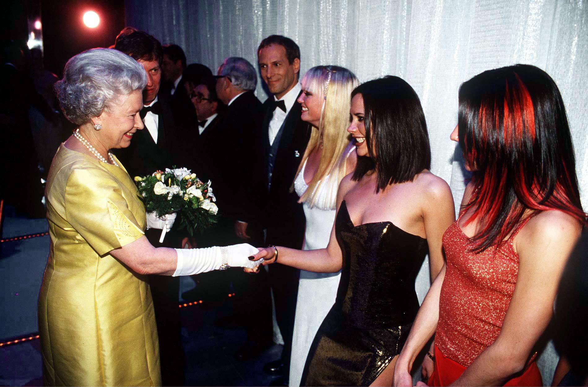 The Queen At The Royal Command Performance At The Victoria Palace Theatre On 1st December 1997 Shaking Hands With Pop Star Victoria Beckham (posh Spice) Of The Pop Band The Spice Girls