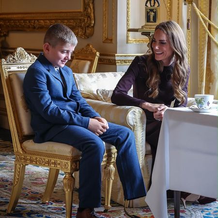 Princess Kate sitting at a table with a little boy wearing a suit