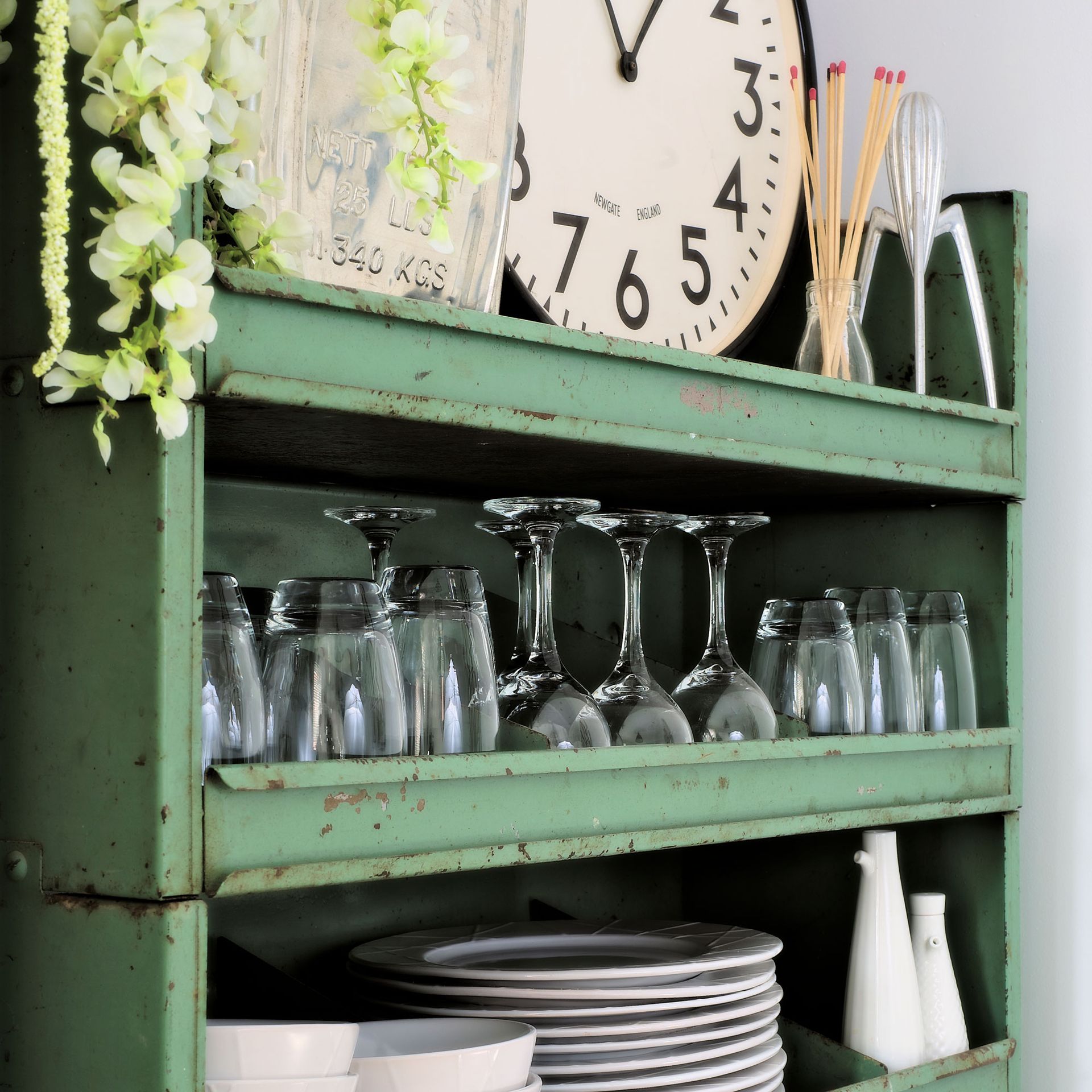 glasses and plates arranged in green shelving unit