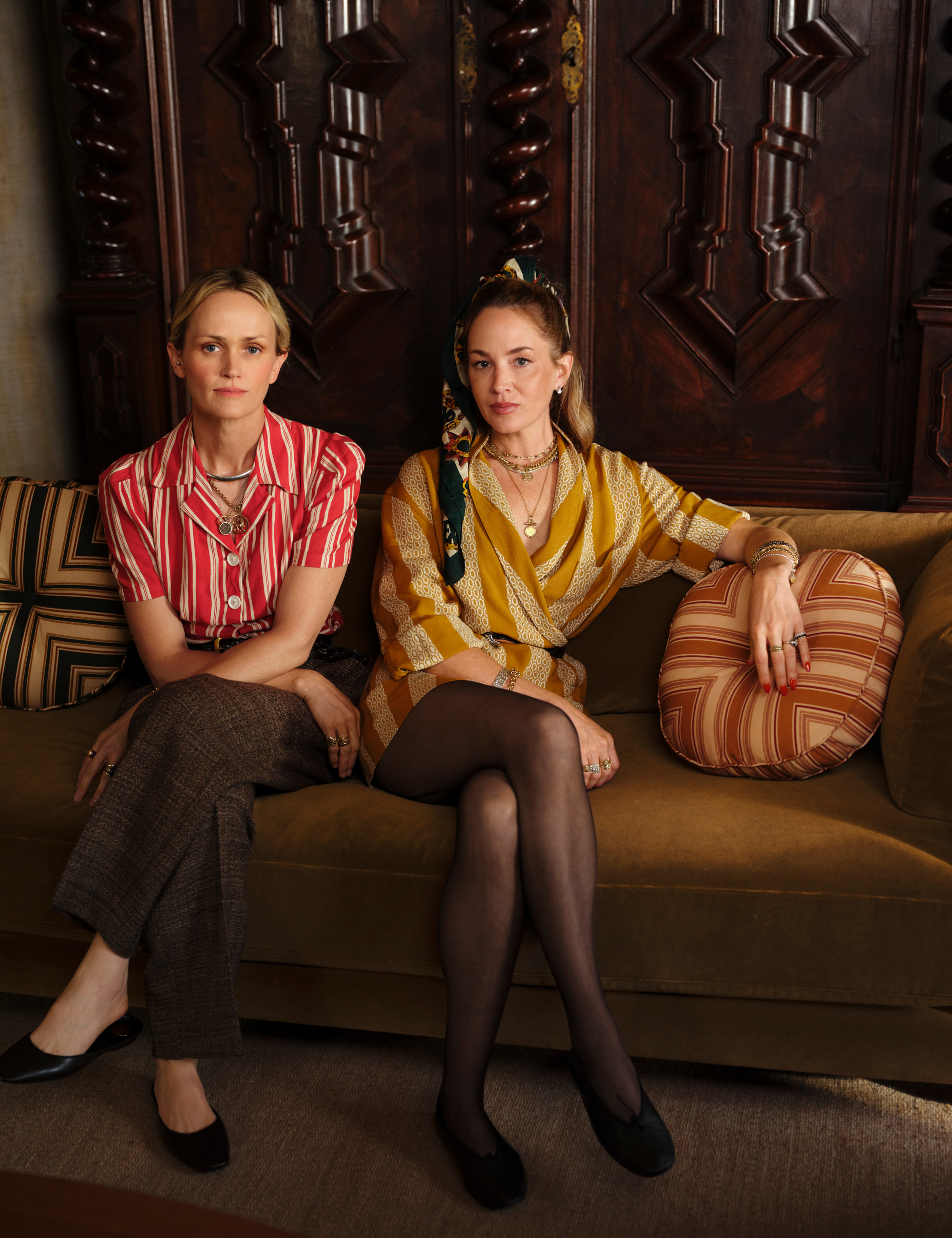 Pierce &amp;amp; Ward founders Louisa Pierce and Emily Ward pose on an olive green couch styled with striped circular pillows to celebrate the launch of their studio's second West Elm collaboration.