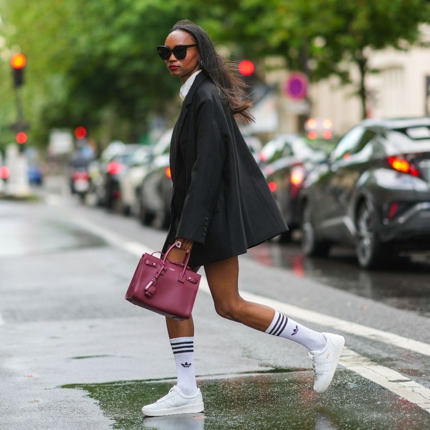 woman wearing trendy new sneakers with a blazer and hermes birkin bag
