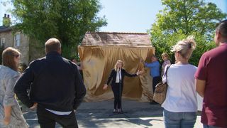 Nicola Wheeler announces the new bus stop as Bob Hope and Vinny Dingle pull down the sheet to unveil the creation.