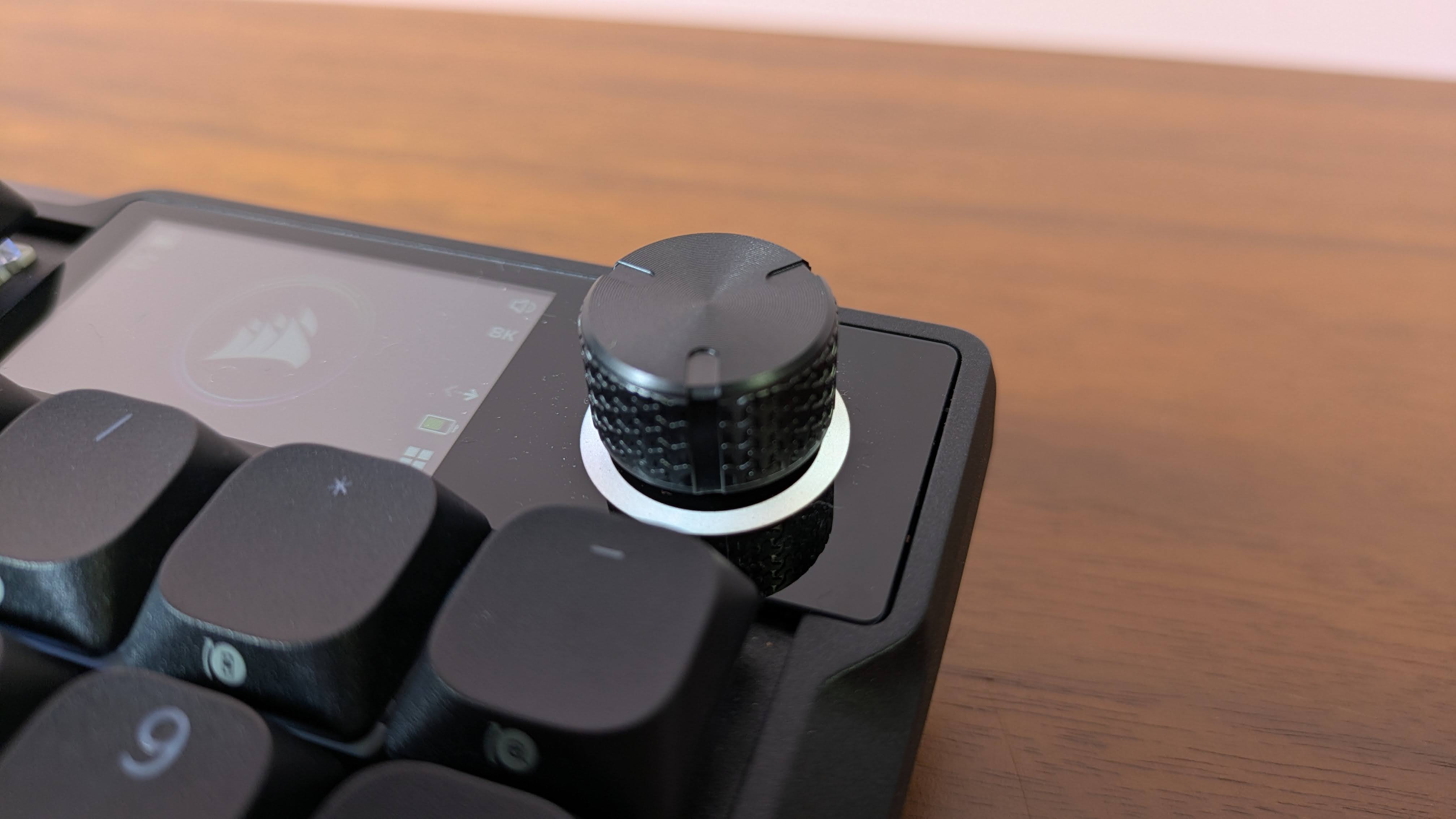 Close-up of rotary dial on Corsair Vanguard Air 99 Wireless on brown desk
