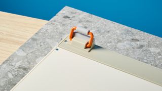 The Lofree Block keyboard on a stone surface with a blue wall in the background.